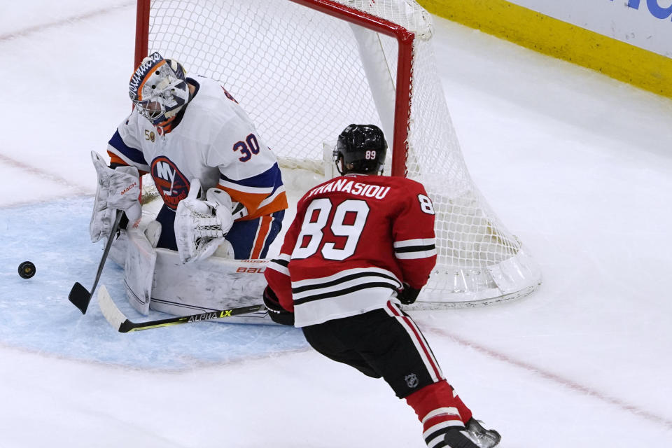 New York Islanders goaltender Ilya Sorokin (30) makes a save on Chicago Blackhawks center Andreas Athanasiou (89) during the second period of an NHL hockey game Tuesday, Nov. 1, 2022, in Chicago. (AP Photo/David Banks)