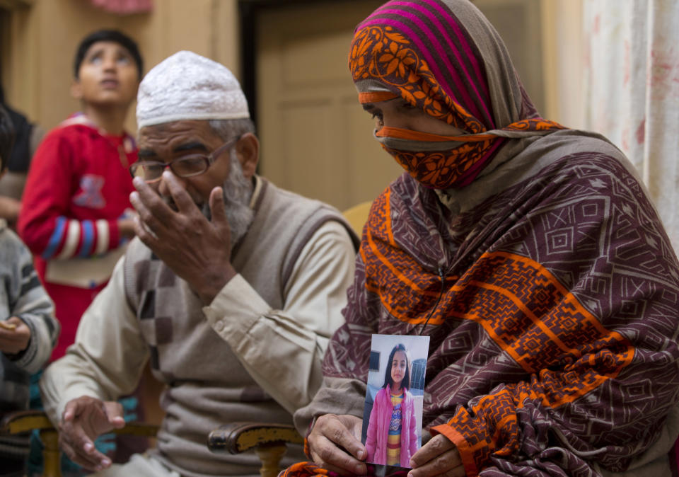 In this Jan. 18, 2018, file photo, Nusrat holds a picture of her daughter Zainab Ansari with her husband Mohammed Amin Ansari, left, in Kasur, Pakistan. Mohammad Imran, a serial killer of eight children, was executed at a Pakistani prison Wednesday morning, Oct. 17, 2018, after the country's top court rejected a request for his public hanging, officials said. Zainab's father Mohammed Amin Ansari was specially allowed to witness the execution. (AP Photo/B.K. Bangash, File)