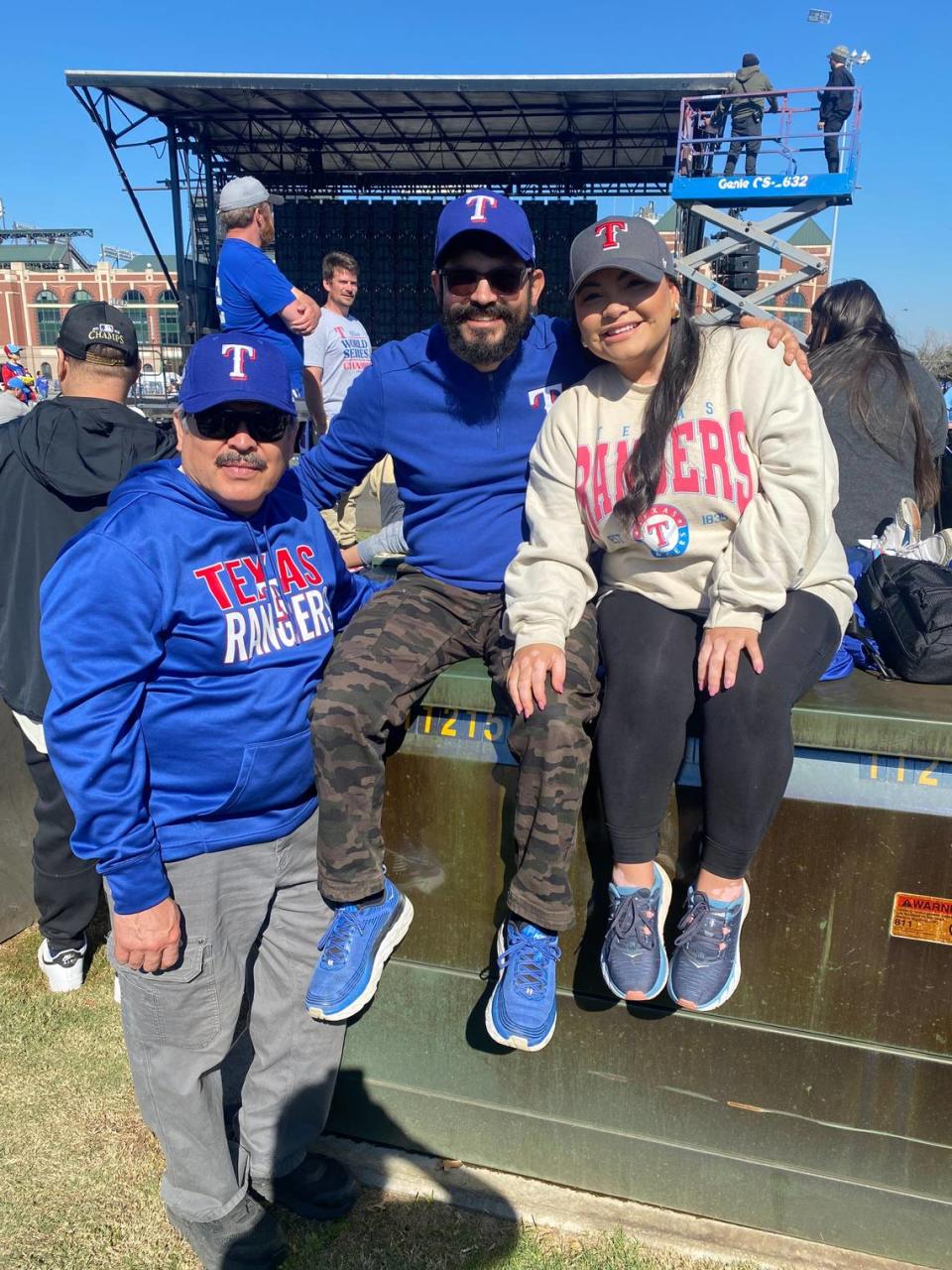 From left to right, Genaro, Jesse and Claudia Santos pose before the Rangers World Series victory parade.