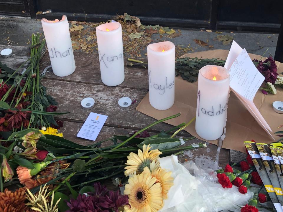 Candles and flowers are left at a make-shift memorial honoring four slain University of Idaho students outside the Mad Greek restaurant in downtown Moscow, Idaho, on Tuesday, Nov. 15, 2022.