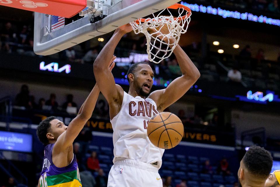 Cleveland Cavaliers forward Evan Mobley (4) dunks against New Orleans Pelicans guard Trey Murphy III, left, during the second half of an NBA basketball game in New Orleans, Friday, Feb. 10, 2023. (AP Photo/Matthew Hinton)