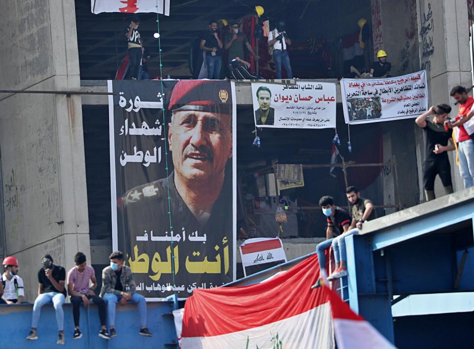 Posters of protesters who have died in anti-government demonstrations and a poster of Lt. Gen. Abdul-Wahab al-Saadi, left, the former commander of the country's elite counterterrorism forces whose dismissal sparked protests about a month ago, hang on a building near Tahrir Square, in Baghdad, Iraq, Sunday, Nov. 3, 2019. (AP Photo/Hadi Mizban)