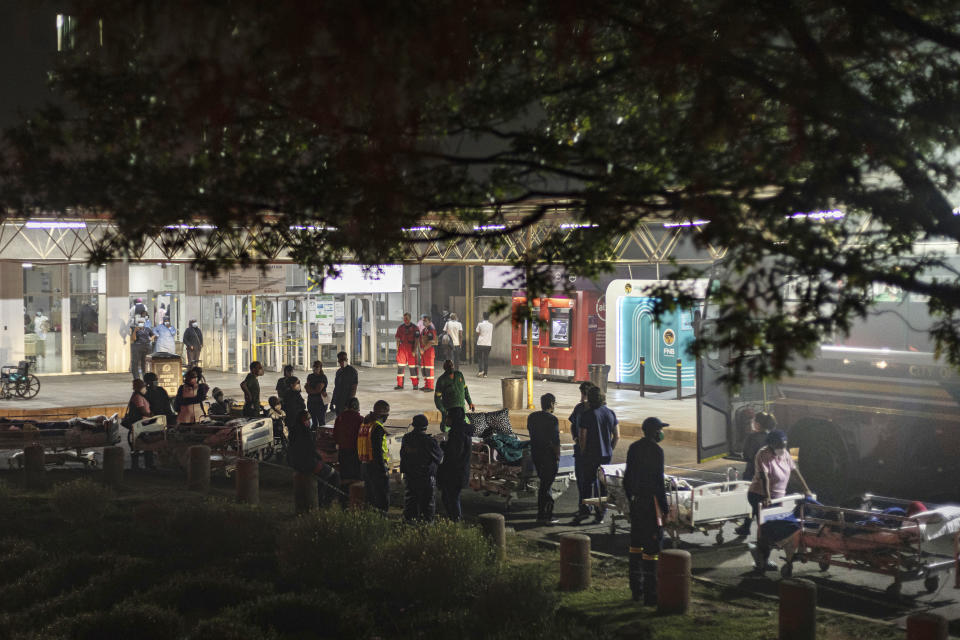 Hospital staff prepare to evacuate patients on stretchers at the Charlotte Maxeke Hospital in Johannesburg, Saturday, April 17, 2021. Patients were evacuated after a fire reignited in a dispensary almost 12 hours after it was initially reported. (AP Photo/Ali Greeff)