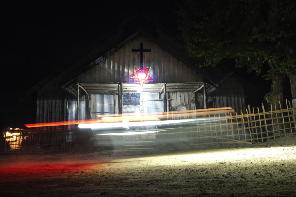 A bike rides past the church in Oting village, in the northeastern Indian state of Nagaland, Wednesday, Dec. 15, 2021. High up in the hills along India's border with Myanmar, Oting village is in mourning after more than a dozen people were killed by soldiers. Grieving villagers have sought solace in the church. (AP Photo/Yirmiyan Arthur)