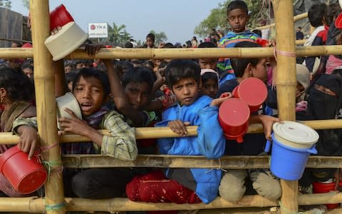 Rohingya Muslim refugees wait for food aid at Thankhali refugee camp in Bangladesh's Ukhia district - Credit:  MUNIR UZ ZAMAN/ AFP