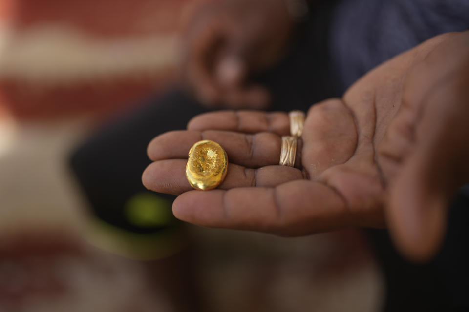 Amerindian teacher Selwyn Miller, a 27-year-old president of the Parent Teacher Association, holds a lump of gold, in Chinese Landing, Guyana, Tuesday, April 18, 2023. Miller hopes the piece of gold will finance his trip to another region of Guyana where he plans to work as a miner to care for his four children after his wife died in childbirth. (AP Photo/Matias Delacroix)