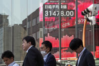 People walk past an electronic stock board showing Japan's Nikkei 225 index at a securities firm Wednesday, Nov. 1, 2023 in Tokyo. Asian shares were mostly higher Wednesday after Wall Street advanced to claim back some of the ground it gave up in another losing month. (AP Photo/Shuji Kajiyama)