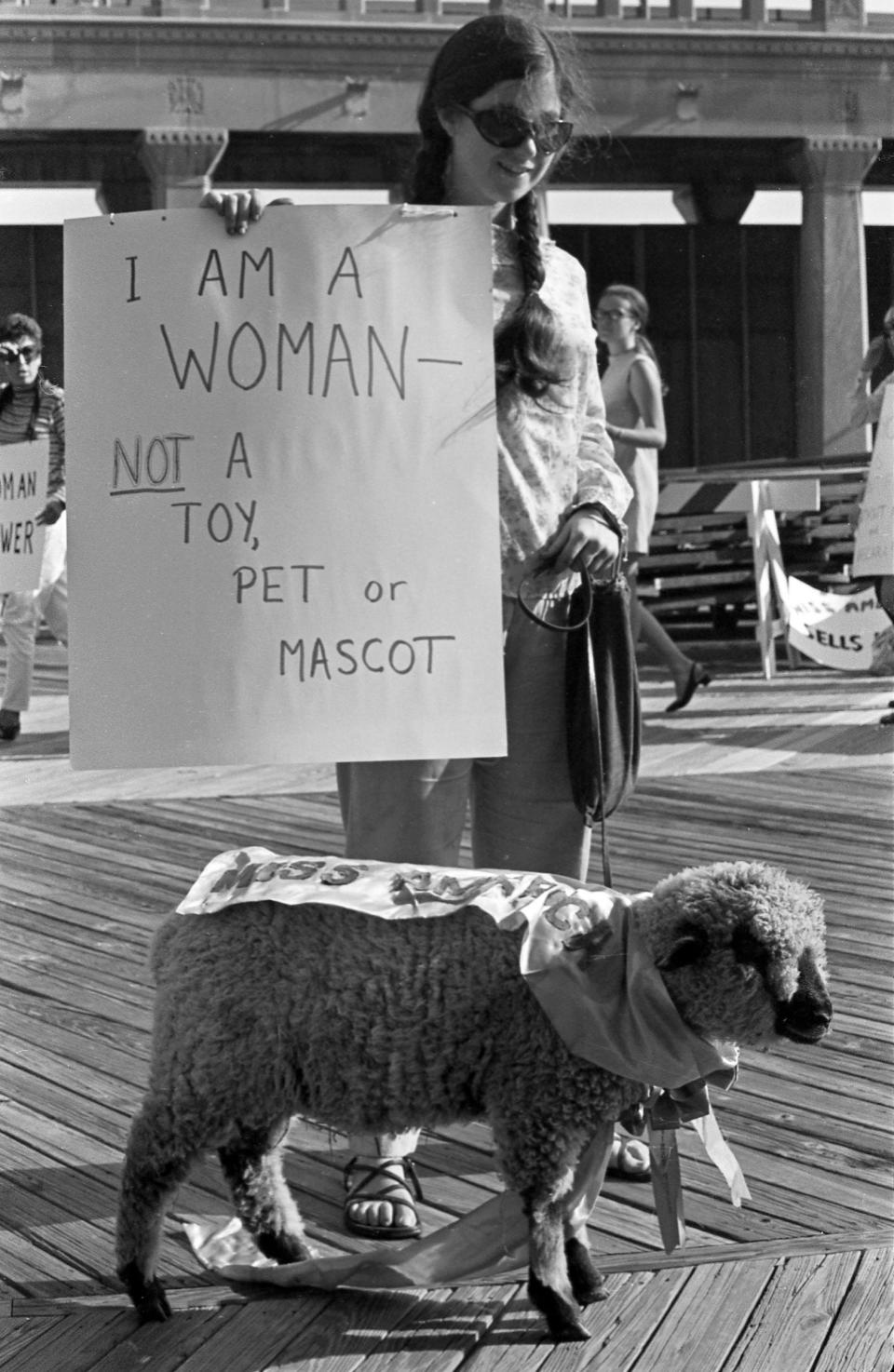 A demonstrator during “No More Miss America” holds a sign saying she is not a toy, pet, or mascot in 1968.