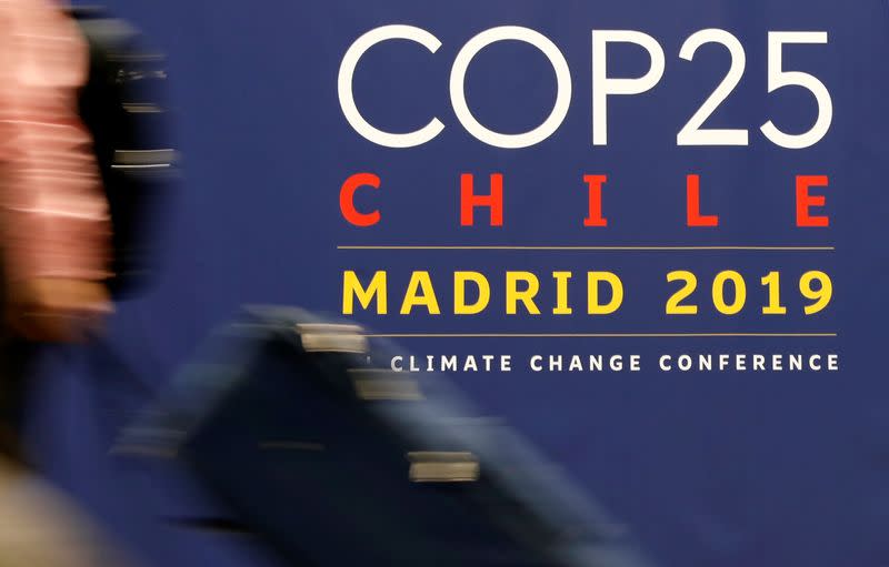 Una mujer pasa ante un cartel de la Conferencia de las Naciones Unidas sobre el Cambio Climático (COP25) en Madrid