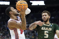 Houston's Reggie Chaney (32) looks to pass as UAB's KJ Buffen (5) defends during the first half of a college basketball game in the first round of the NCAA tournament, Friday, March 18, 2022, in Pittsburgh. (AP Photo/Keith Srakocic)