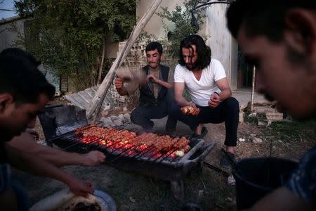 Crew of a film directed by Humam Husari grill meat after the end of filming in the rebel held Douma neighbourhood of Damascus, Syria October 6, 2016. REUTERS/Bassam Khabieh