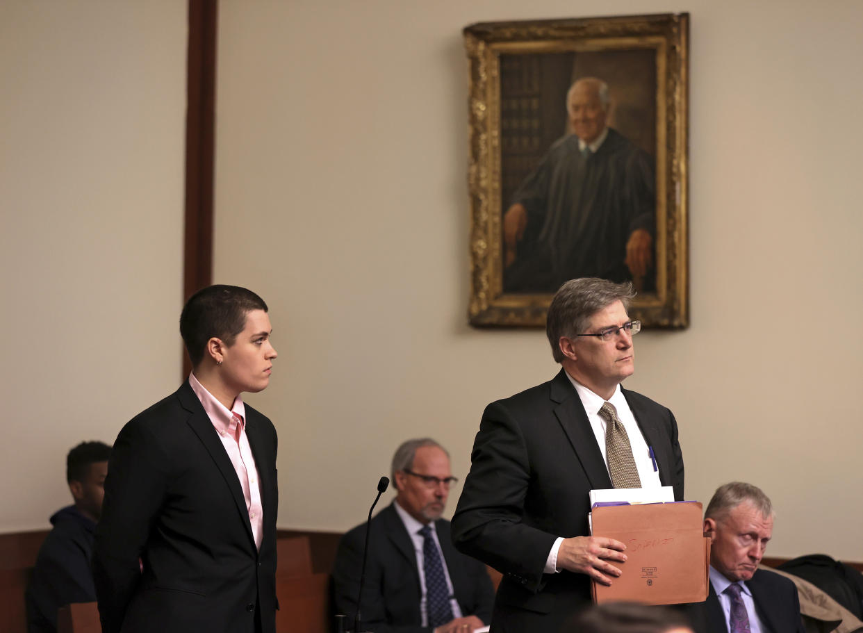 Riley Dowell, left, stands with an attorney during arraignment at Boston Municipal Court, Monday, Jan. 23, 2023. Dowell, the daughter of U.S. Rep. Katherine Clark of Massachusetts was arrested during a protest Saturday night on Boston Common and later charged with assault after a police officer was injured. Dowell, 23, is accused of defacing the Parkman Bandstand Monument with spray paint before she was arrested, officials said. (David L Ryan/The Boston Globe via AP, Pool)