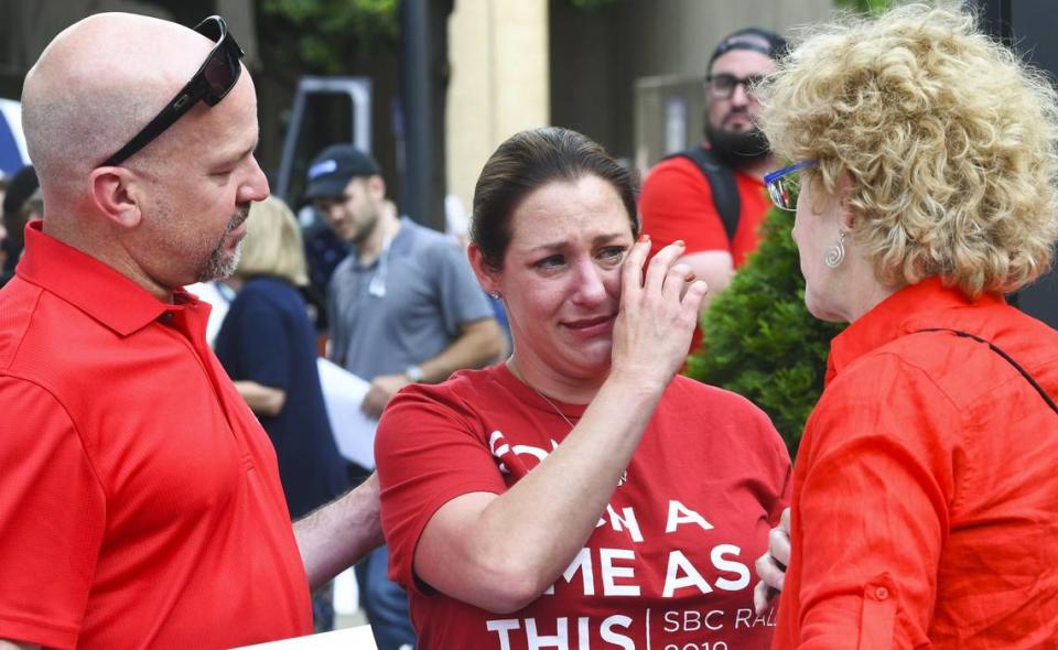 Jules Woodson, center, is comforted by her boyfriend during a demonstration outside the Southern Baptist Convention’s annual meeting in Birmingham, Ala. in 2019. Woodson spoke through tears as she described being abused sexually by a Southern Baptist minister.