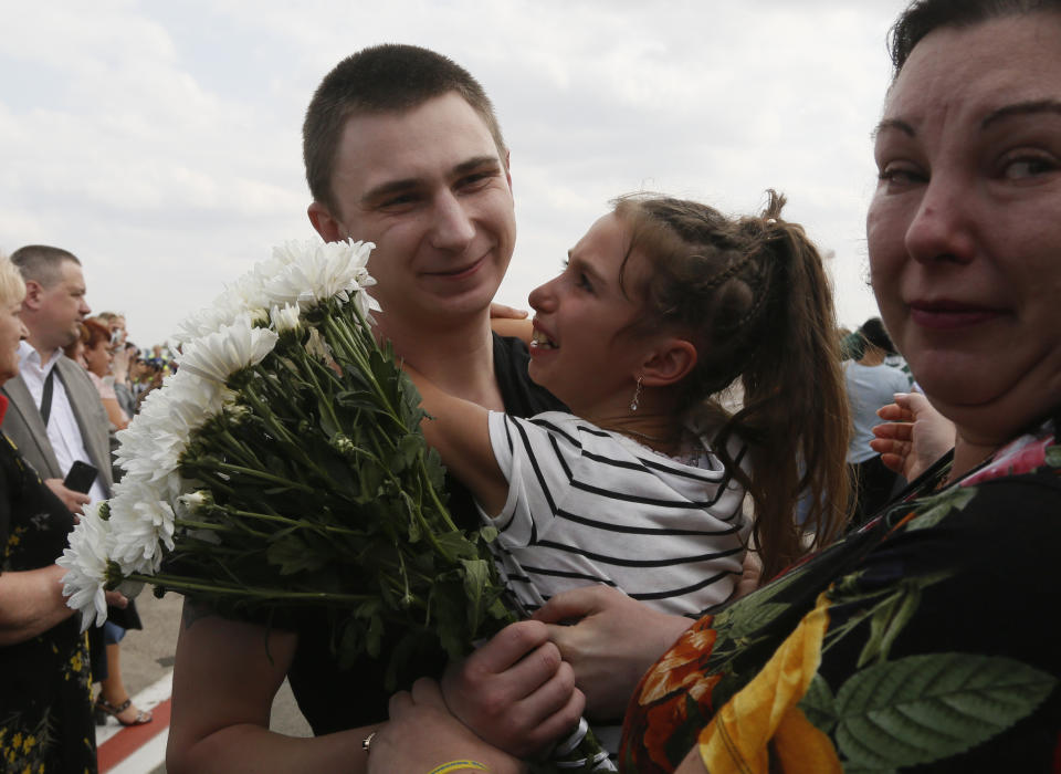 Relatives of Ukrainian prisoners freed by Russia greet them upon their arrival at Boryspil airport, outside Kyiv, Ukraine, Saturday, Sept. 7, 2019. Planes carrying prisoners freed by Russia and Ukraine have landed in the countries' capitals, in an exchange that could be a significant step toward improving relations between Moscow and Kyiv. The planes, each reportedly carrying 35 prisoners, landed almost simultaneously at Vnukovo airport in Moscow and at Kyiv's Boryspil airport. (AP Photo/Efrem Lukatsky)