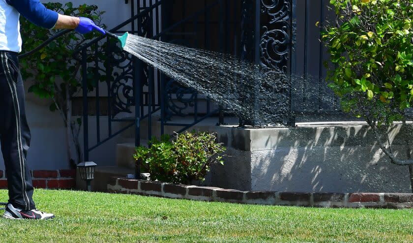 A man waters his lawn in Alhambra, California on April 27, 2022, a day after Southern California delared a water shortage emergency, with unprecedented new restrictions on outdoor watering for millions of people living in Los Angeles, San Bernardino and Ventura counties. - Southern California's Metropolitan water district will allow for outdoor watering tp just one day per week effective June 1st. (Photo by Frederic J. BROWN / AFP) (Photo by FREDERIC J. BROWN/AFP via Getty Images)