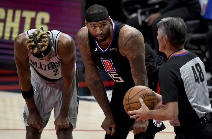 Los Angeles Clippers center DeMarcus Cousins, center, talks with official referee Scott Foster, right, as Portland Trail Blazers forward Rondae Hollis-Jefferson, left, listens during the second half of an NBA basketball game in Portland, Ore., Tuesday, April 20, 2021. The Clippers won 113-112. (AP Photo/Steve Dykes)