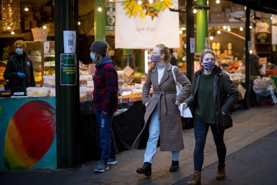 Two women wear face masks walking through London this week. Source: Getty