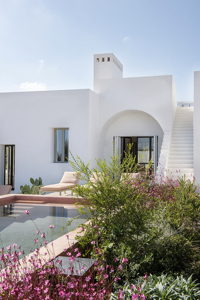 <p>Contrastant avec les murs chaulés de la maison, la margelle du bassin a été façonnée dans un béton rose poudré qui se marie délicatement aux buissons de fleurs plantés alentour et aux bains de soleil « Timeless » ( <a href="http://www.gandiablasco.com/fr/" rel="nofollow noopener" target="_blank" data-ylk="slk:Gandia Blasco;elm:context_link;itc:0;sec:content-canvas" class="link ">Gandia Blasco</a>)</p><br>