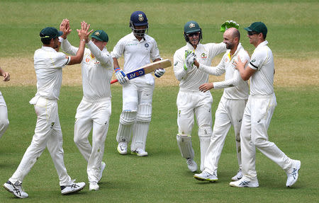 Australia's Nathan Lyon (2nd R) celebrates with teammates after taking his fifth wicket, dismissing India's Ajinkya Rahane (C) on day four of the first test match between Australia and India at the Adelaide Oval in Adelaide, Australia, December 9, 2018. AAP/Dave Hunt/via REUTERS