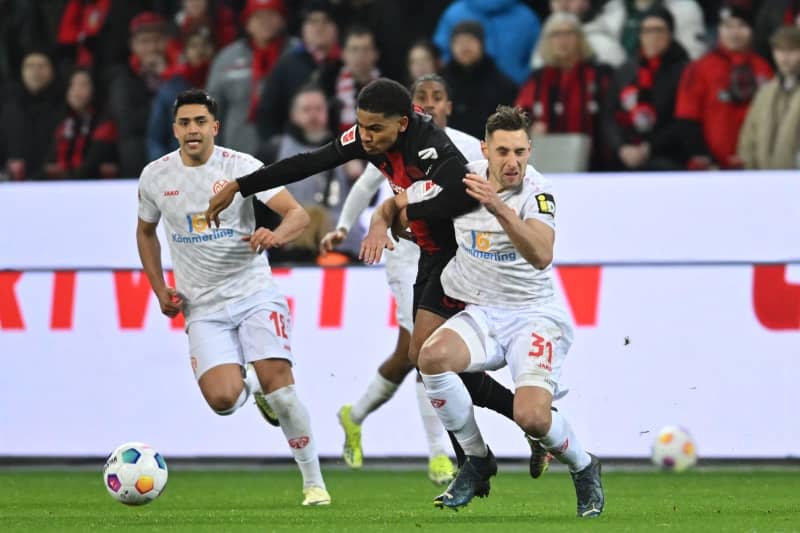 Mainz's Nadiem Amiri (L) and Dominik Kohr and Leverkusen's Amine Adli battle for the ball during the German Bundesliga soccer match between Bayer Leverkusen and FSV Mainz 05 at BayArena. Marius Becker/dpa