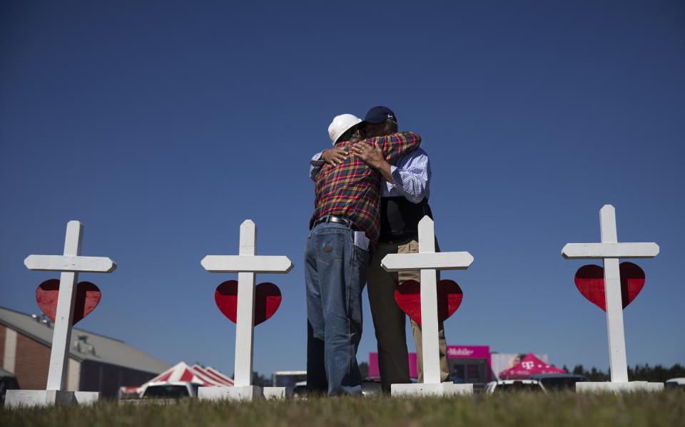 Rev. Arthur Thomas, right, of Mt. Nebo Baptist Church, right, is embraced by Greg Zanis who built a cross for each victim of the tornado and placed them as a makeshift memorial in Beauregard, Ala., Wednesday, March 6, 2019. Thomas said several of the dead were members of his congregation. (AP Photo/David Goldman)