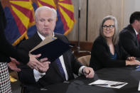 Arizona Supreme Court Chief Justice Robert Brutinel, left, hands over the official Arizona general election canvass document to Arizona Elections Director Kori Lorick as Katie Hobbs, the Democratic governor-elect and current secretary of state, right, looks on during a signing ceremony at the Capitol in Phoenix, Monday, Dec. 5, 2022. (AP Photo/Ross D. Franklin, Pool)