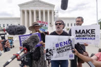 Rev. Patrick Mahoney, center, chief strategy officer for Stanton Healthcare, an Idaho-based pregnancy center that does not provide abortions, is flanked by Katie Mahoney, left, and supporter Kevin Krueger, right, as he speaks to the press outside the Supreme Court on Thursday, June 27, 2024, in Washington. The Supreme Court cleared the way Thursday for Idaho hospitals to provide emergency abortions for now in a procedural ruling that left key questions unanswered and could mean the issue ends up before the conservative-majority court again soon. (AP Photo/Mark Schiefelbein)