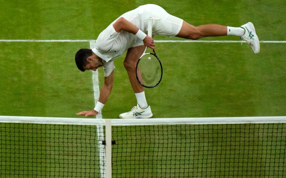 Serbia's Novak Djokovic touches the grass as he celebrates defeating Tim van Rijthoven of the Netherlands during a men's fourth round singles match on day seven of the Wimbledon tennis championships in London, Sunday, July 3 - Alastair Grant/AP