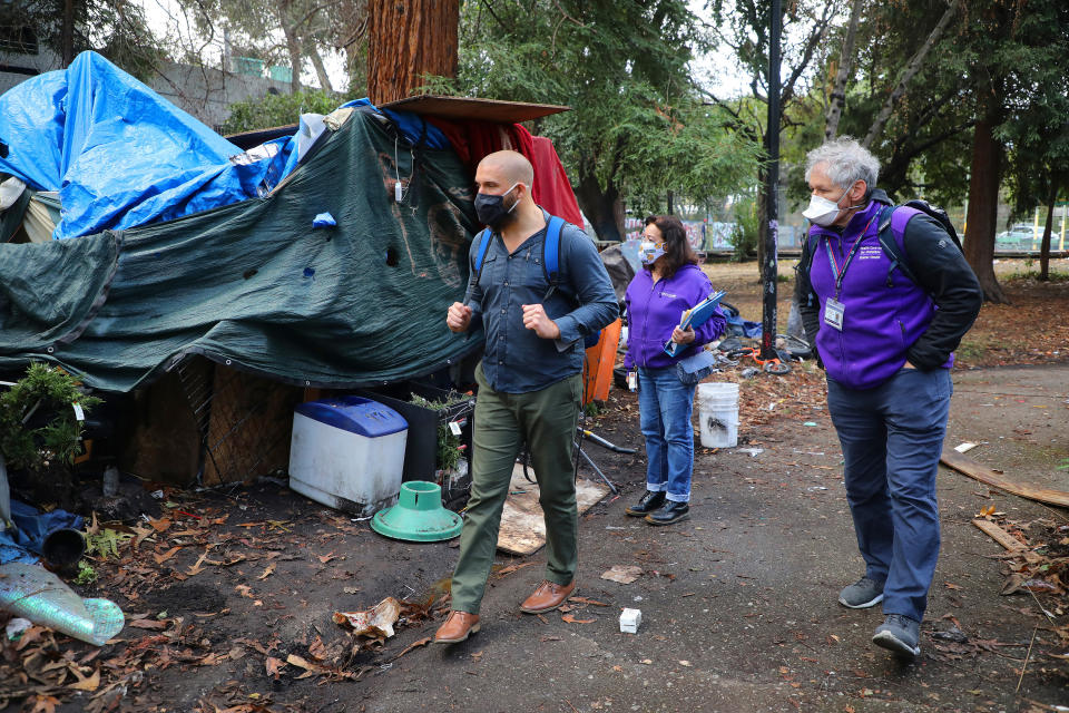 Un equipo de atención a personas sin hogar, desde la izquierda: Benjamin Durant, médico; Wilma Lozada, trabajadora social, y Harrison Alter, médico, en un campamento para personas en situación de calle en Oakland, California, el 8 de diciembre de 2020. (Jim Wilson/The New York Times)