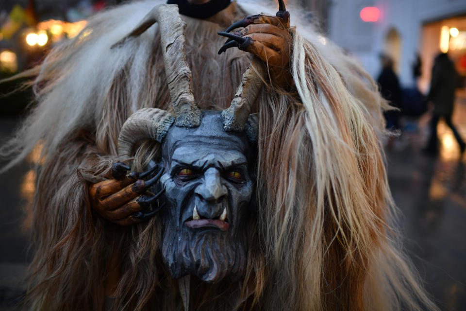 MUNICH, GERMANY - DECEMBER 09: An actor carries the mask of a Krampus creature after a parade through the city center's pedestrian shopping district on December 9, 2018 in Munich, Germany. Krampus traditionally accompanies Saint Nicholas and angels in a house to house procession to reward children who have been good and warn those who have not, though in recent decades Krampus parades have become an intrinsic part of local folklore and take place throughout the end of November and into the first half of December in the alpine regions of Germany, Austria and Italy. Krampus usually wears large cowbells on his back that he rings by shaking his hips to ward off the evil spirits of winter. He also carries a switch made of branches or animal hair that he uses to whip bystanders. (Photo by Sebastian Widmann/Getty Images)