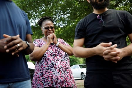 Local resident Sandra Moore becomes emotional while praying with other members of her church near a municipal government building where a shooting incident occurred in Virginia Beach, Virginia