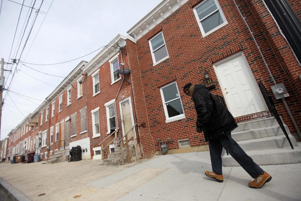 
A pedestrian walks down 22nd Street near Lamont where some homes have been renovated amongst a few vacant ones. 
