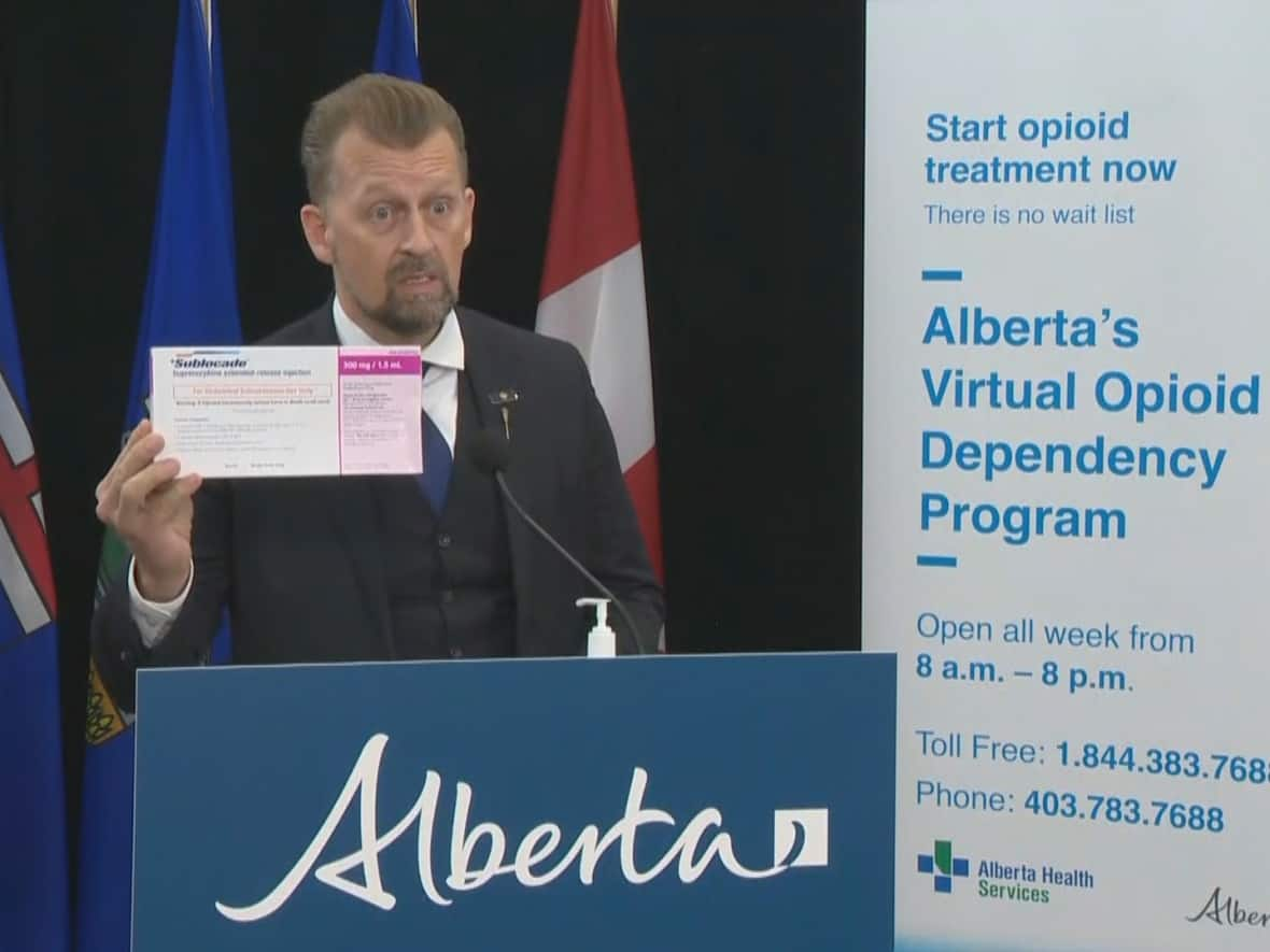 Mike Ellis, Alberta's associate minister of mental health and addictions, holds up a box of Sublocade. The injectable drug will now be fully funded by the province for people diagnosed with addictions to opioids. (Pool feed - image credit)