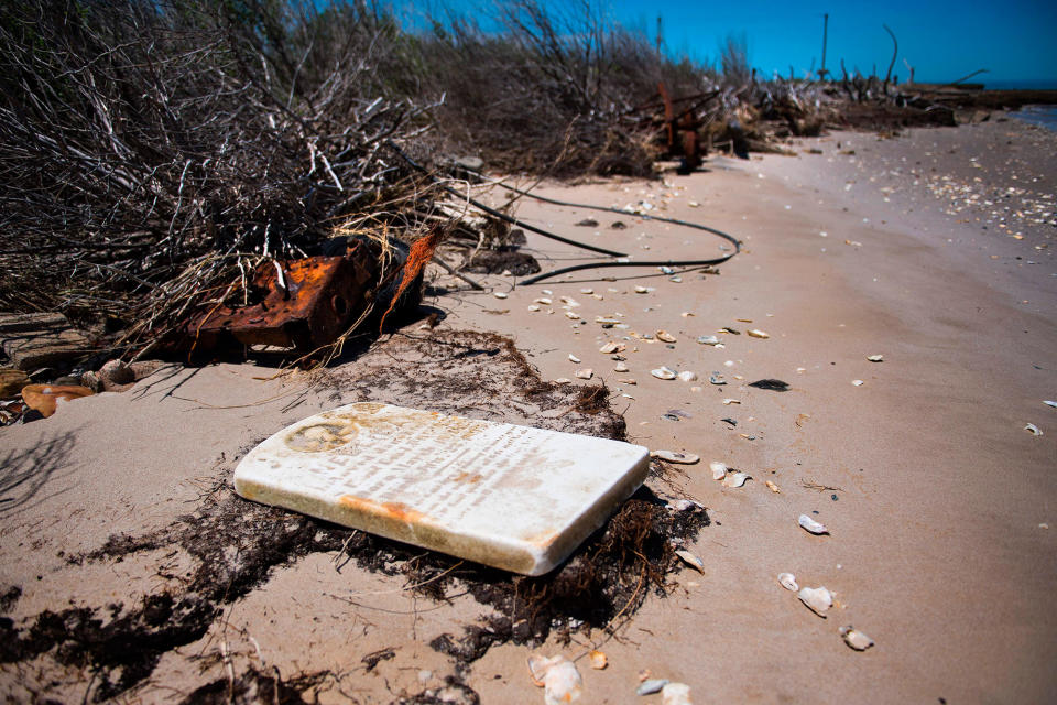 <p>A grave stone rests on the beach where a cemetery once stood but has been washed away due to erosion in an area called Canaan in Tangier, Virginia, May 16, 2017, where climate change and rising sea levels threaten the inhabitants of the slowly sinking island.<br> (Jim Watson/AFP/Getty Images) </p>