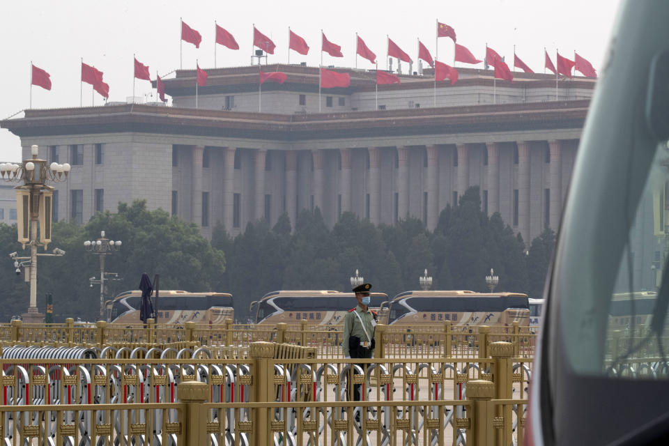 A Chinese paramilitary policeman wearing a mask to curb the spread of the new coronavirus stands guard as delegates attending the opening session of the Chinese People's Political Consultative Conference (CPPCC) arrive on buses in front of the Great Hall of the People in Beijing, Thursday, May 21, 2020. (AP Photo/Ng Han Guan)