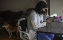 Natty Jumreornvong, a Thai-born medical student at the Icahn School of Medicine at Mount Sinai, reads a tablet after arriving home, Thursday April 29, 2021, in New York. Jumreornvong, a victim of anti-Asian attacks, is among medical professionals of Asian and Pacific Island descent who feel the anguish of being racially targeted because of the virus while toiling to keep people from dying of it. (AP Photo/Bebeto Matthews)