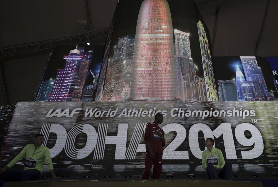 Mutaz Essa Barshim of Qatar, center and the gold medal winner, speaks on the podium with Mikhail Akimenko and Ilya Ivanyuk, both competing as a neutral athlete, after the medal ceremony for the the men's high jump final was postponed at the World Athletics Championships in Doha, Qatar, Friday, Oct. 4, 2019. (AP Photo/Nariman El-Mofty)