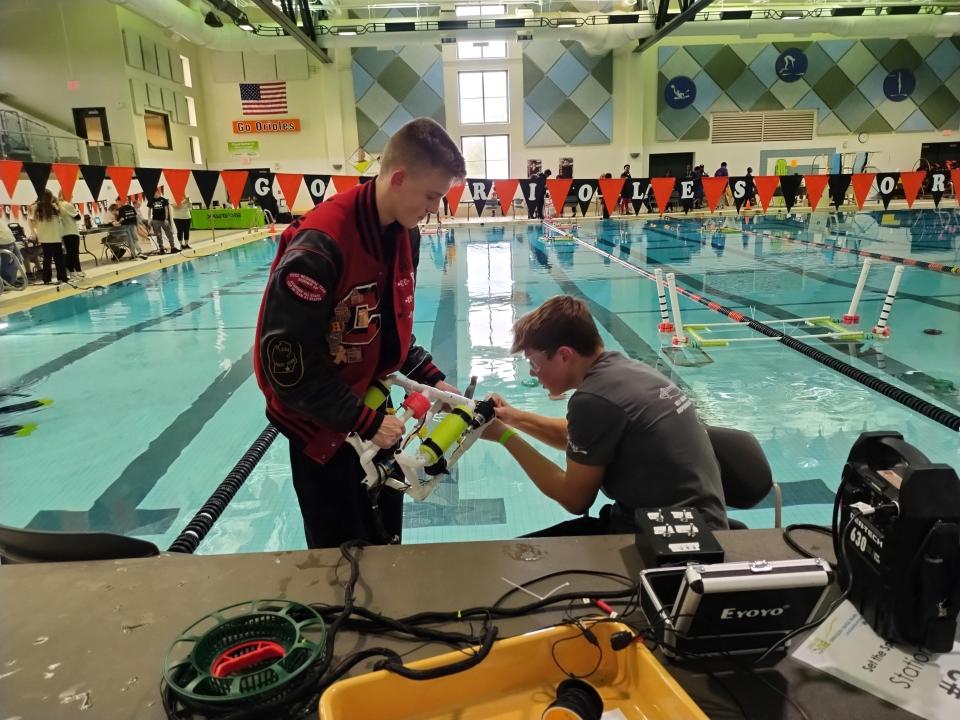Gabe Manchester, left, and Jaren Settles, right, students at Clinton High School are seen March 20, 2024, working on their remotely operated vehicle (ROV) during an underwater robotics competition hosted at the Charlotte Aquatic Center. The Advanced STEM students won first place in the Ambassador Project, first place in the Perfect Pitch competition and first place for Overall Performance in the Senior Division.