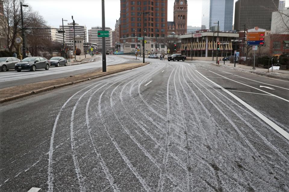 Stripes from an ice melting mix are left on the road after being applied along West Kilbourn Avenue at North Old World Third Street looking east. The mix is more efficient than regular road salt, officials say.