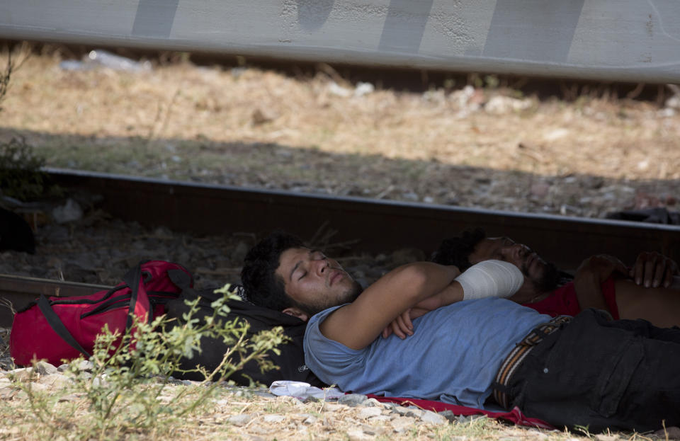 A Central American migrant takes a nap in the shade under a freight train car, during his journey toward the US-Mexico border, in Ixtepec, Oaxaca State, Mexico, Tuesday, April 23, 2019. Whereas in late 2018 and early 2019 Mexican authorities were handing out humanitarian visas and processing asylum requests, they have now largely stopped doing so, instead making migrants wait weeks in the southern town of Mapastepec for visas that never come. (AP Photo/Moises Castillo)