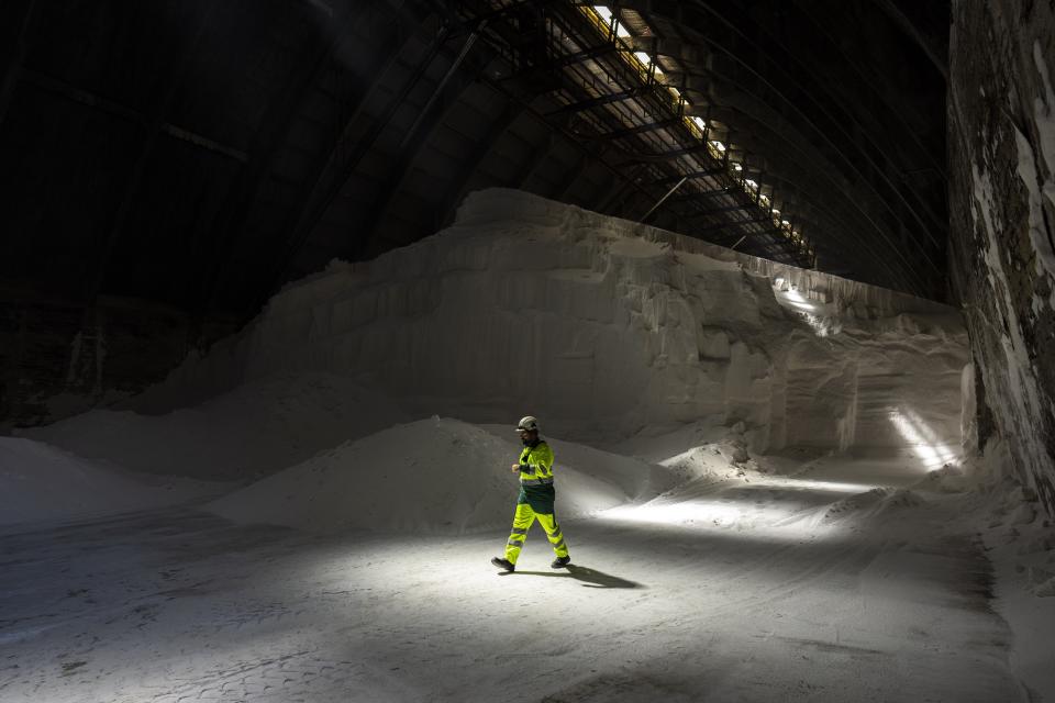 A worker walks inside an ammonium nitrate warehouse at the Fertiberia industrial complex in Puertollano, central Spain, Tuesday, March 28, 2023. Spanish energy company Iberdrola and fertilizer manufacturer Fertiberia partnered to create the first zero-carbon plant nutrients in the world. The fertilizer will one day be scattered onto malt barley, which will then be used to make Heineken's first "green malt" beverage. (AP Photo/Bernat Armangue)