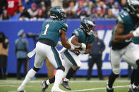 Philadelphia Eagles quarterback Jalen Hurts, left, hands off to Boston Scott during the second half of an NFL football game against the New York Giants, Sunday, Nov. 28, 2021, in East Rutherford, N.J. (AP Photo/John Munson)