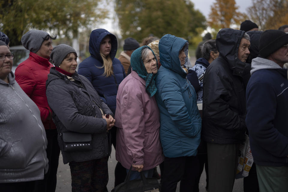 People wait in line as humanitarian aid is distributed at the village of Mykhailo Lukasheve, in Zaporizhzhia region, Ukraine, Thursday, Oct. 20, 2022. (AP Photo/Leo Correa)