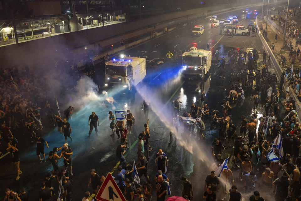 Riot police tries to clear demonstrators with a water canon during a protest against plans by Netanyahu's government to overhaul the judicial system, in Tel Aviv, Monday, July 24, 2023. Israeli lawmakers on Monday approved a key portion of Prime Minister Benjamin Netanyahu's divisive plan to reshape the country's justice system despite massive protests that have exposed unprecedented fissures in Israeli society. (AP Photo/Oded Balilty)