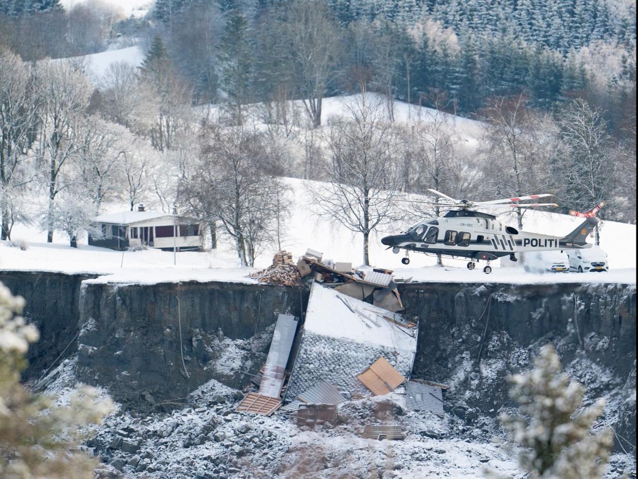 <p>A police helicopter joins the rescue operation in the village of Ask in Gjerdrum municipality near Oslo</p> (Reuters)