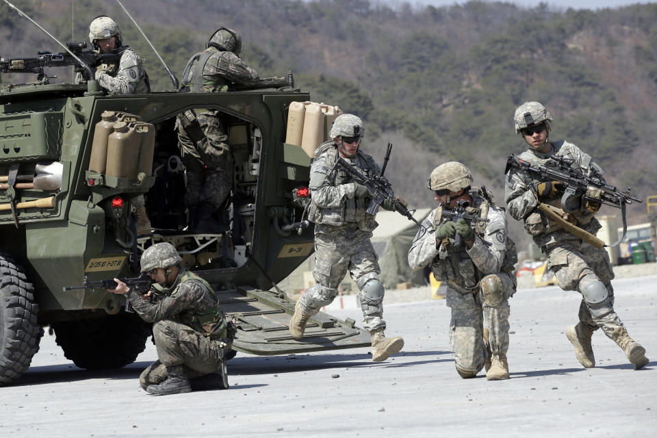 FILE - In this March 25, 2015, file photo, U.S. Army soldiers from the 25th Infantry Division's 2nd Stryker Brigade Combat Team and South Korean soldiers take their positions during a demonstration of the combined arms live-fire exercise as part of the annual joint military exercise between South Korea and the United States at the Rodriquez Multi-Purpose Range Complex in Pocheon, north of Seoul, South Korea. The South Korean and U.S. militaries have postponed on Thursday, Feb. 27, 2020, their annual joint drills out of concerns over a virus outbreak. (AP Photo/Lee Jin-man, File)