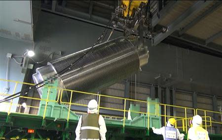 The cask with 22 fuel rods is lifted and moved by workers during operations to move the cask from the reactor building to another building where a common fuel pool is located, at Tokyo Electric Power Co's (TEPCO) Fukushima Daiichi nuclear power plant in Fukushima prefecture, November 21, 2013, in this handout video grab image taken and released by TEPCO. REUTERS/Tokyo Electric Power Co/Handout via Reuters. ATTENTION EDITORS - PICTURE HAS BEEN DIGITALLY MASKED FROM SOURCE