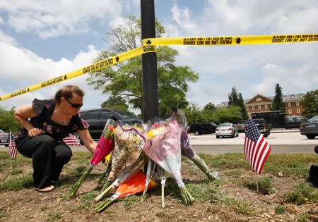 A resident places flowers at a makeshift memorial outside a municipal government building where a shooting incident occurred in Virginia Beach, Virginia