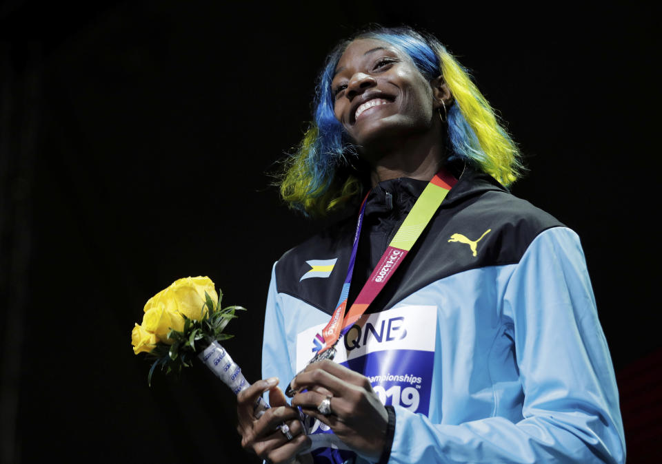 FILE - In this Oct. 4, 2019, file photo, Shaunae Miller-Uibo of Bahamas, silver, smiles during the medal ceremony for the women's 400-meter the World Athletics Championships in Doha, Qatar. Miller-Uibo won gold in Rio with a dive at the finish of the 400 meters. She's diving in at the Tokyo Games with plans to not only defend her title but chase after gold in the 200 meters. (AP Photo/Nariman El-Mofty, File)