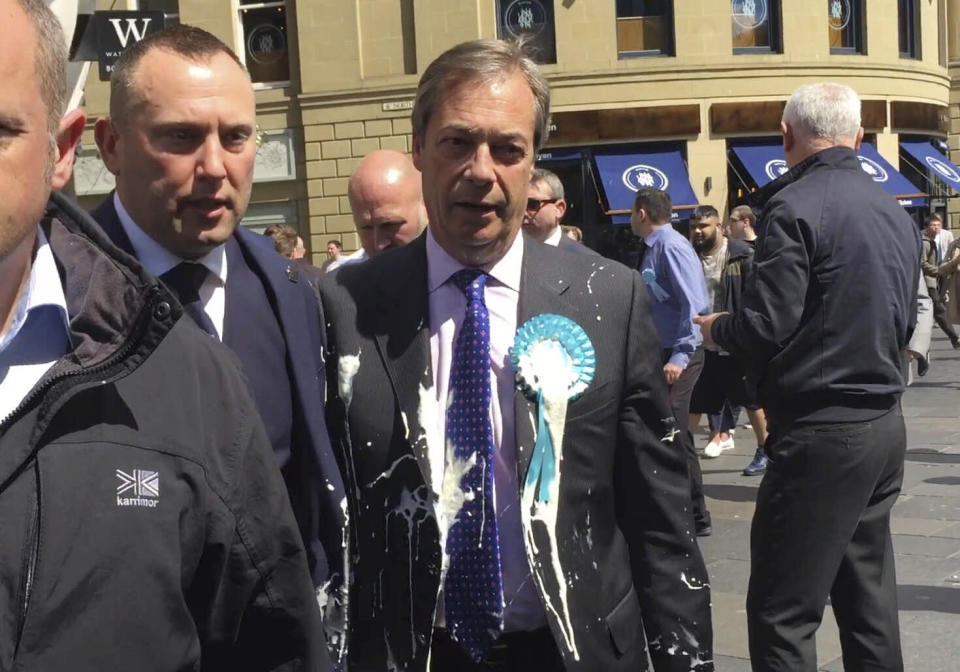 El dirigente del Partido Brexit británico, Nigel Farage, es alcanzado por un vaso de batido de leche durante un acto de campaña para las elecciones al Parlamento Europeo, en Newcastle, Inglaterra, 20 de mayo de 2019. (Tom Wilkinson/PA via AP)